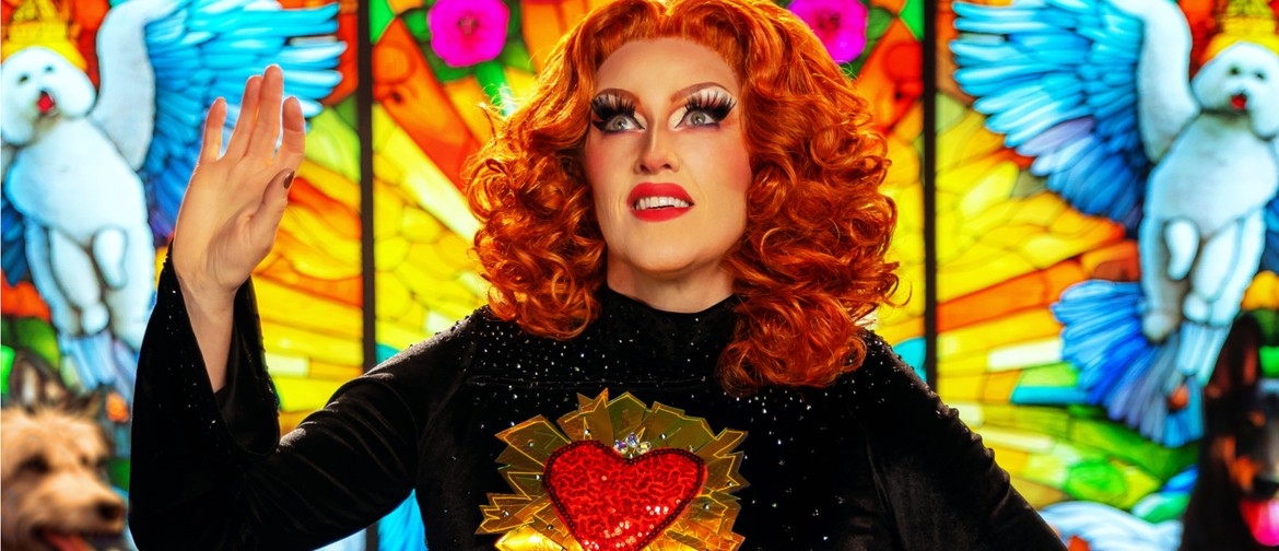 Glamorous red-haired woman in black rhinestoned gown smiling and posing in front of a stained-glass window, evocative of Catholic iconography