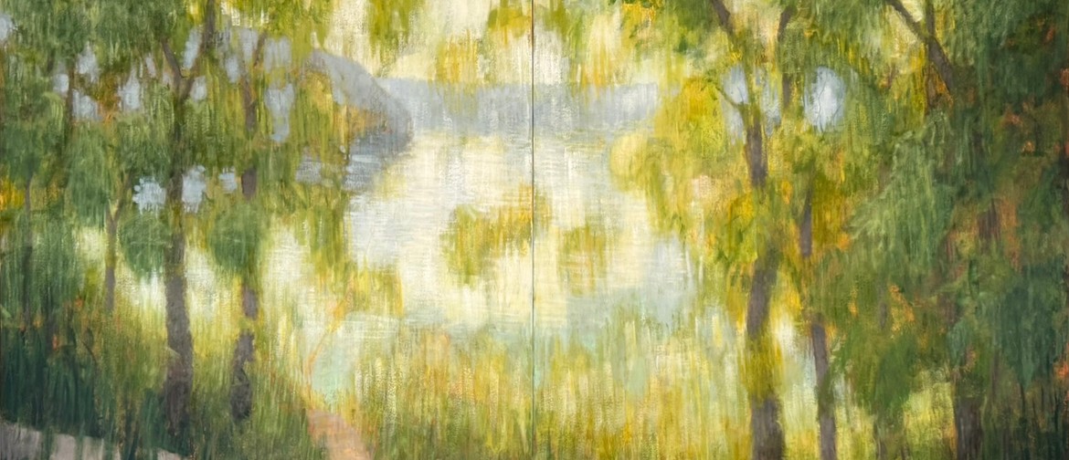 Dual Nature A group of tall, green, sun-dappled trees shroud a still lake at sundown, shallow hills rising on either side. The late afternoon light tinges the water a pale golden