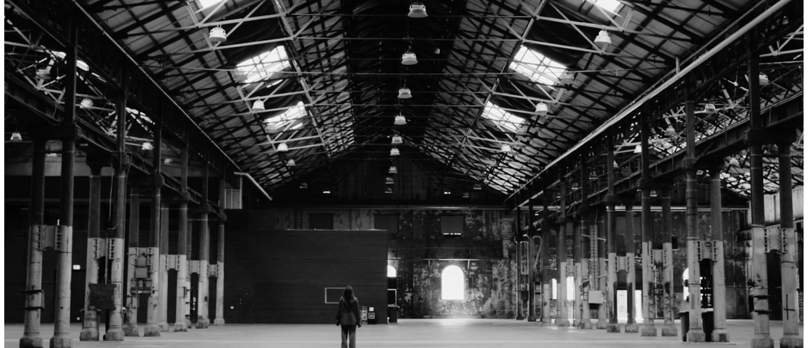 FRMEFEST 2025 - Australia's first visual storytelling summit woman dressed in black standing in the middle of a large empty warehouse space