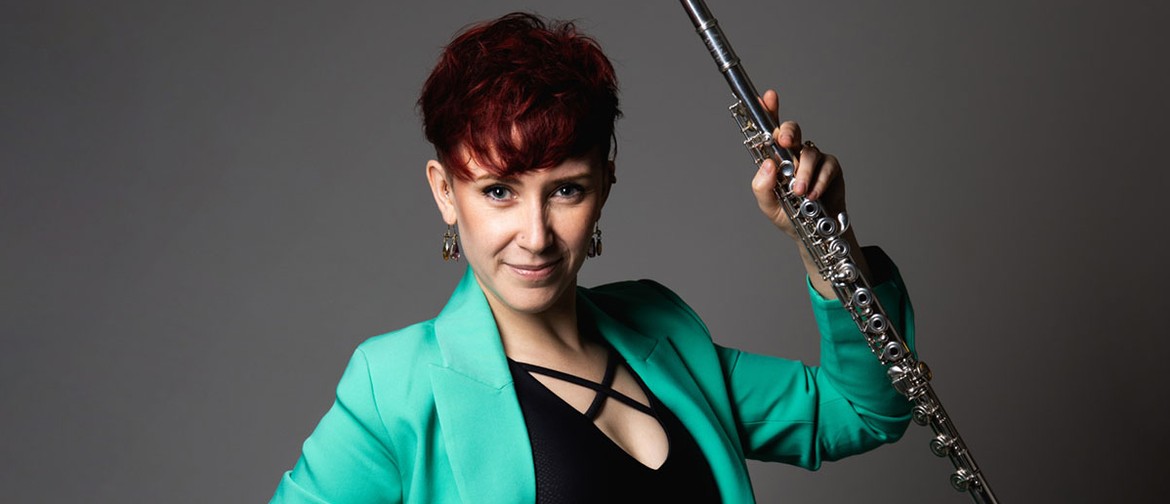 Classic Kids: Eliza's Orchestral Adventures Eliza Shephard holds her flute triumphantly, wearing a turquoise blazer, black top in front of a grey backdrop