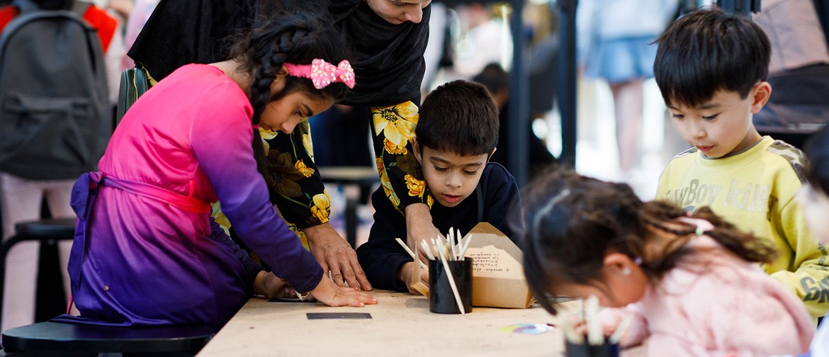 Photograph of a group of children participating in craft activities at a table.