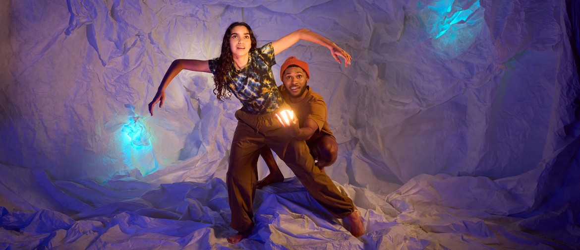 A man and woman explore a cave surrounded by glowing blue lights 