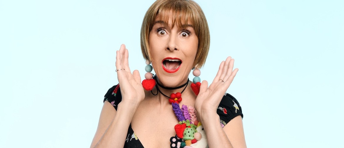 A woman with bobbed, honey hair hold her hands up to her face, with a surprised expression. She wears felt accessories and a black, print dress.