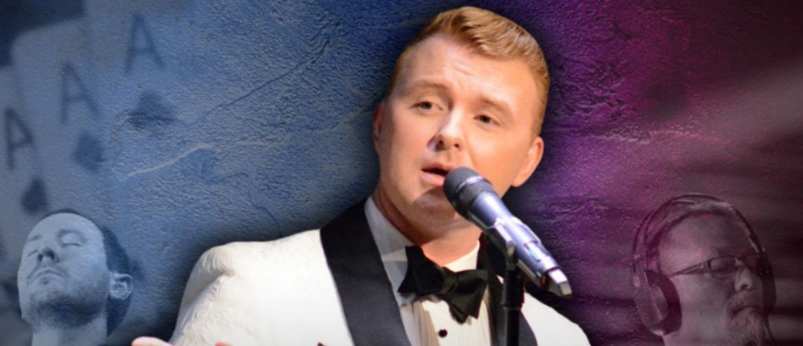 man in white tux with black trim and tie singing into a microphone