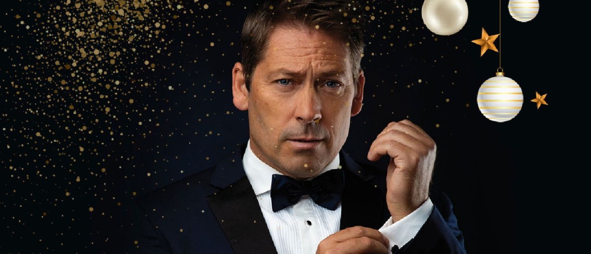 man in black tux with white shirt and black bow tie hand on cuff